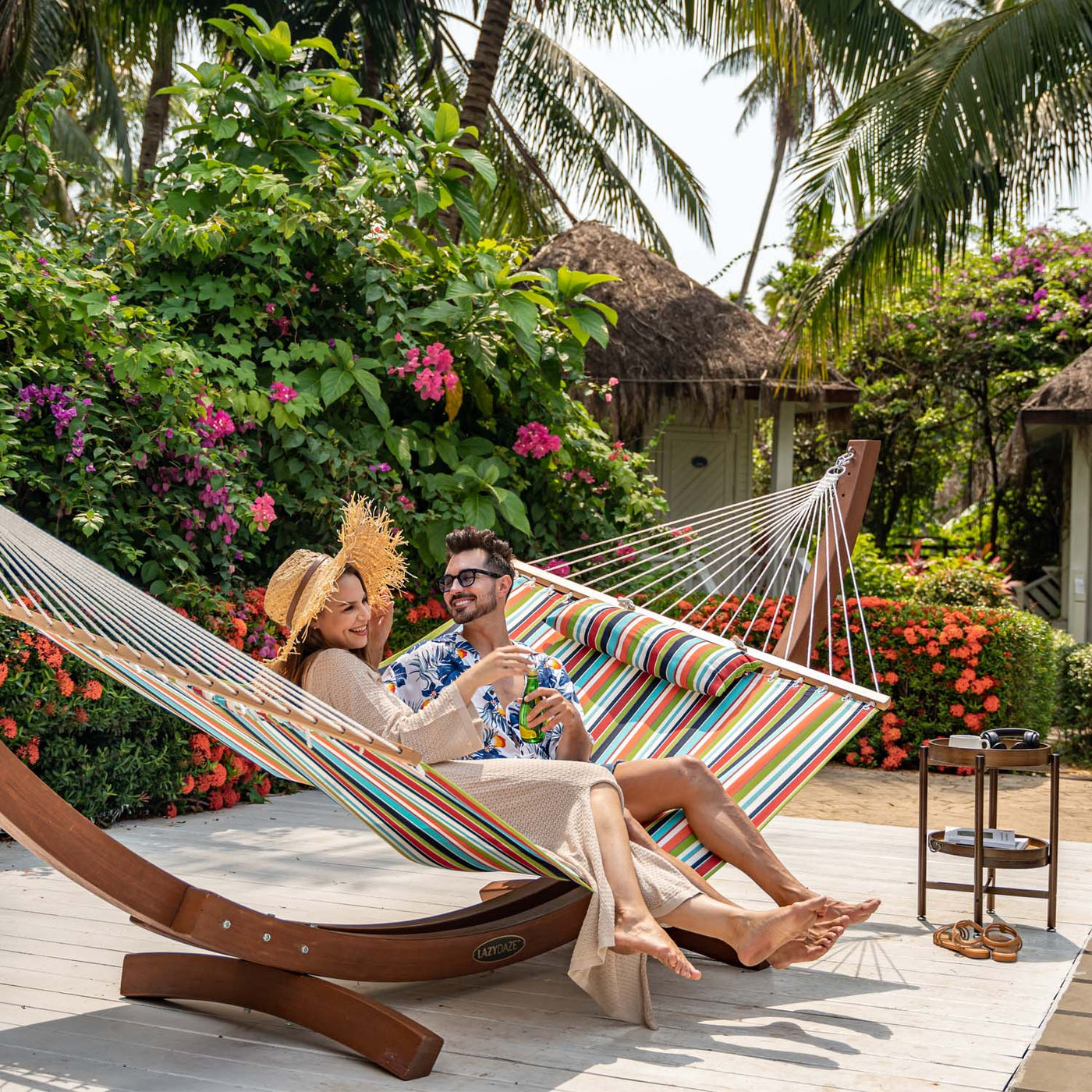 A couple relaxing in the Lazy Daze Sunbrella Single-layer Hammock in orange in the garden.#color_orange