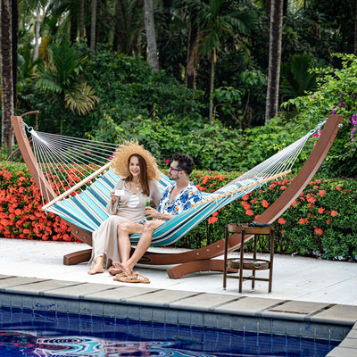 A person relaxing on the Lazy Daze Sunbrella Single Layer Hammock in a peaceful backyard setting.